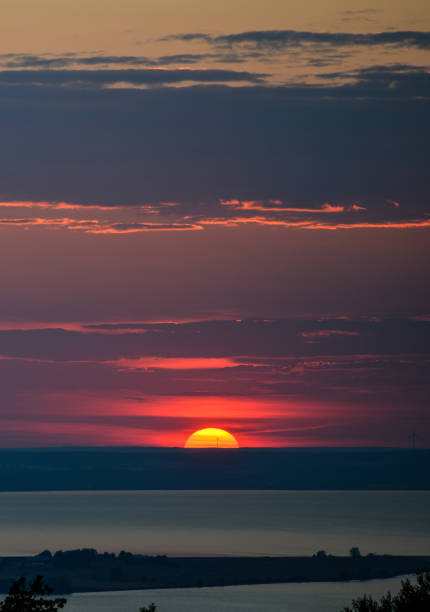 Perfect sunset Sun going down the horizon in front of a windmill jonkoping stock pictures, royalty-free photos & images