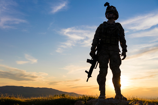 Soldier saluting with the setting sun rays