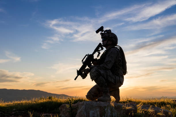 soldado se arrodilló en el campo mirando hacia adelante - counter terrorism fotografías e imágenes de stock