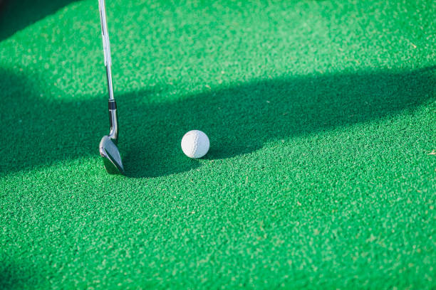istock Side view of a golf ball lying on an green lawn 1225111346
