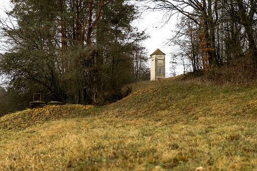 A water tower at a glade, while winter, upon a hill.