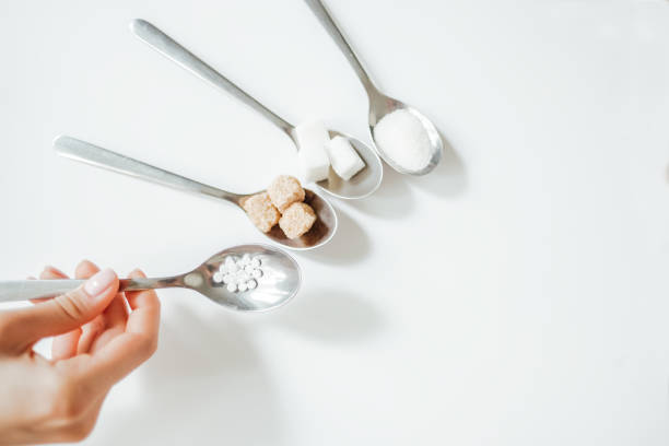 istock Different types of sugar, the hand holds a spoon with a sugar substitute 1225114185