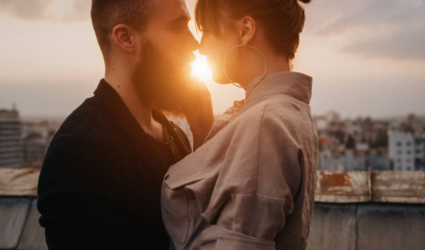 istock Young couple kissing during evening date 1225116020
