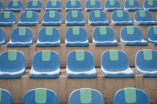 No people on blue plastic chairs of empty tribune at spacious modern stadium for fans of various sports matches, competitions and games