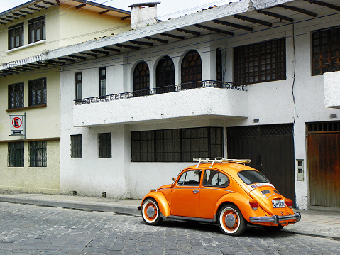 Cuenca, Ecuador - December 22, 2018: Yellow-orange retro car Volkswagen Beetle parked at the city street in Cuenca, Ecuador