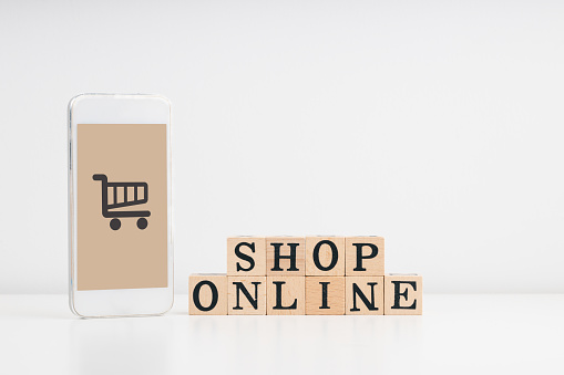 Shopping online, Shop from home, and home delivery concept. SHOP ONLINE wording on a stack of wooden blocks and smartphone mockup with cart icon. white background.
home delivery