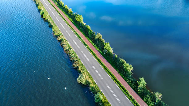 vista aerea dei droni della strada autostradale e della pista ciclabile sulla diga di polder, traffico automobilistico dall'alto, olanda settentrionale, paesi bassi - causeway foto e immagini stock