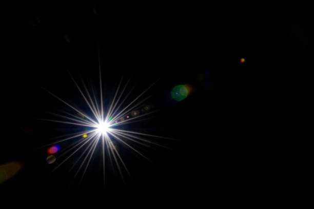 effetto raggi di sole splende su sfondo nero. la luce del sole spot flash o luce stellare brillano sull'obiettivo. luci bokeh astratte e riflessione ottica che perde. - riflesso sullobiettivo foto e immagini stock