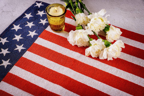 istock Burning candle with flowers on US flag background. Remembrance Day. 1225140791