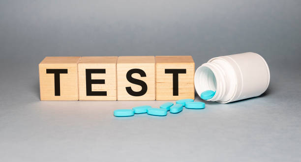 istock inscription test on wooden cube blocks on a gray background with scattered blue pills from a white jar 1225145213