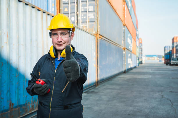 istock Foreman worker working checking at Container cargo harbor holding radio walkie-talkie to loading containers. Dock male staff business Logistics import export shipping concept. 1225145512