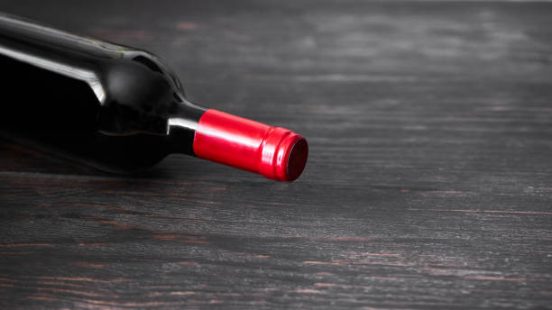 istock Red wine bottle on wooden background.  Wine making and wine degustation concept. Toned image with copy space 1225147128