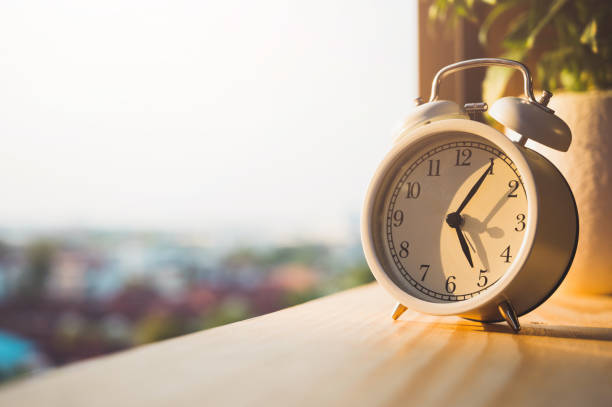 istock Alarm Clock on wooden in the morning with sunlight. 1225147319