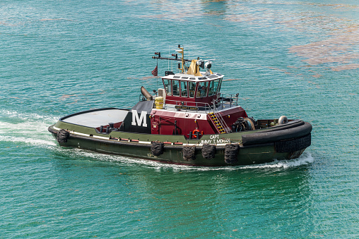 Miami, FL, United States - April 27, 2019: Tugboat Capt. Jimmy T. Moran (Towing Vessel) traveling along MacArthur Causeway in Biscayne Bay in the Port of Miami, Florida, United States of America.