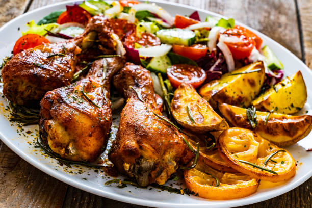 istock Roast chicken drumsticks and vegetables served on wooden table 1225151303