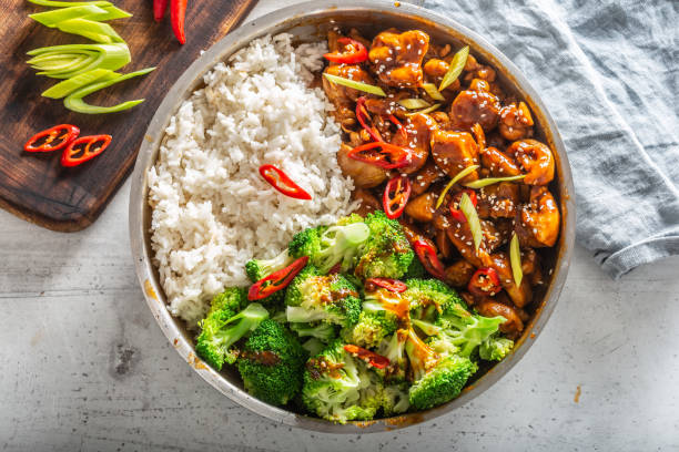 istock Top view of a teriyaki chicken with rice, broccoli and chilli on a white table 1225151659