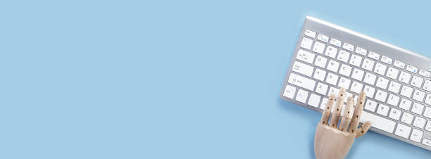 istock Computer keyboard pad on blue background, minimal style. Workspace with a wooden hand 1225154716