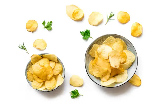 Potato chips in bowls isolated on white background. Homemade oven baked crispy potato chips, top view, copy space.