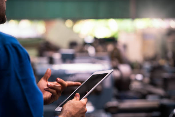 istock Engineers and skilled technicians are maintaining machinery. Professional technicians are holding a tablet to control work in industrial plants. Selective focus. 1225156157