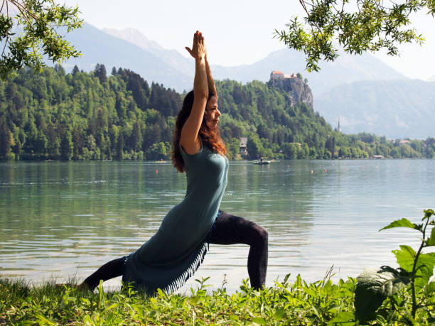 istock Woman Practicing Yoga on Pier Overlooking Lake Bled 1225163124
