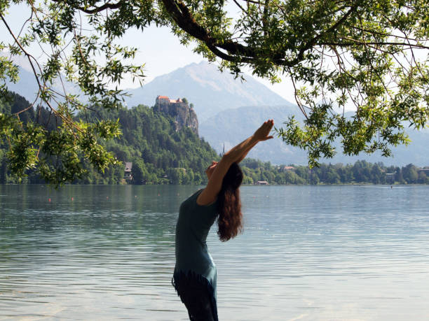 istock Woman Practicing Yoga on Pier Overlooking Lake Bled 1225163130