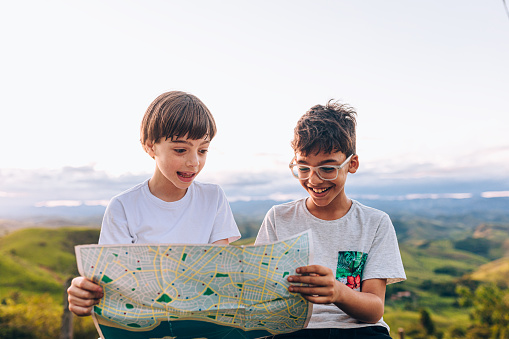 Two kids looking at map making travel plans