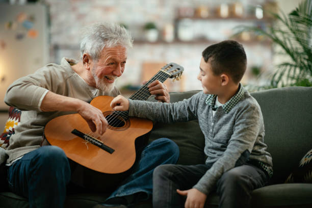 istock Grandfather and grandson playing guitar. 1225165429