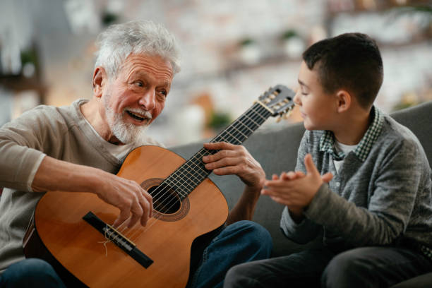 istock Grandfather and grandson playing guitar. 1225165440