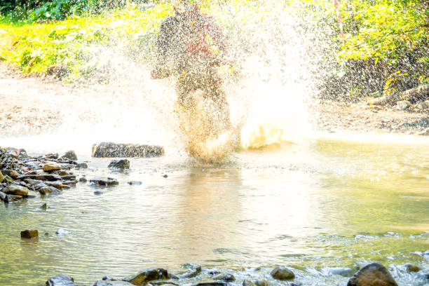 Spray From a Motorcycle in a Sunny Summer Forest