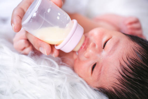 istock Babies are drinking milk from bottles. Mother is breastfeeding. 1225167135