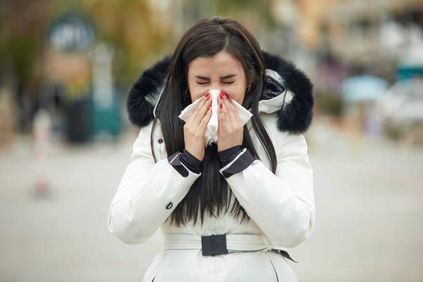 istock Woman coughing and blowing her nose 1225168844