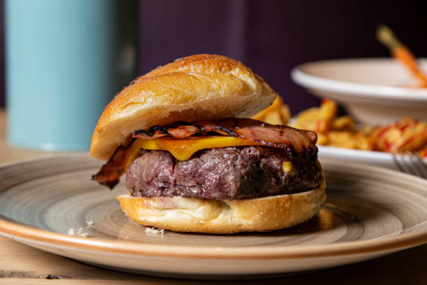 istock Rustic beef burger with cheese and bacon served on a plate. 1225168896