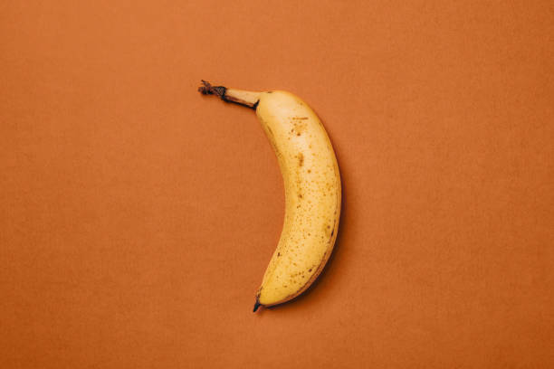 오렌지 배경에 갈색 반점이있는 잘 익은 바나나 - banana rotting ripe above 뉴스 사진 이미지