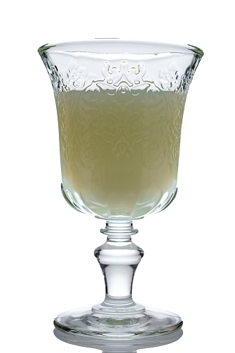 Jade green absinthe in a crystal glass on white