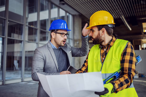istock Frustrated architect yelling at contractor because he made mistake. Building in construction process interior. 1225171409