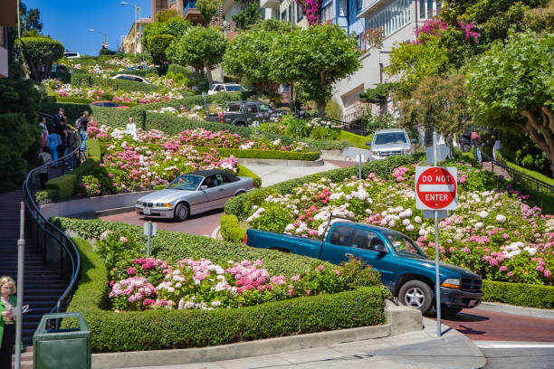 cars passing the Lombard street in San Francisco. It is  known for the  section on Russian Hill between Hyde and Leavenworth, in which the roadway has eight turns stock photo