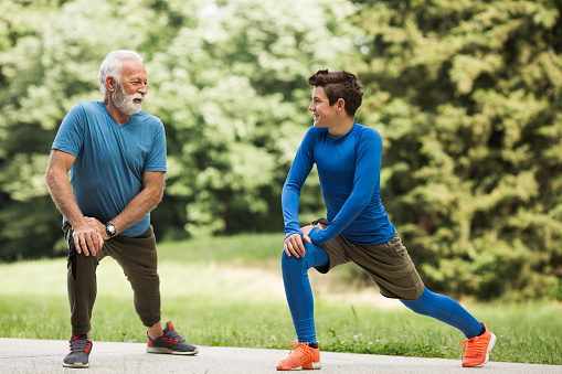 Grandfather and his grandson stretching in nature living healthy