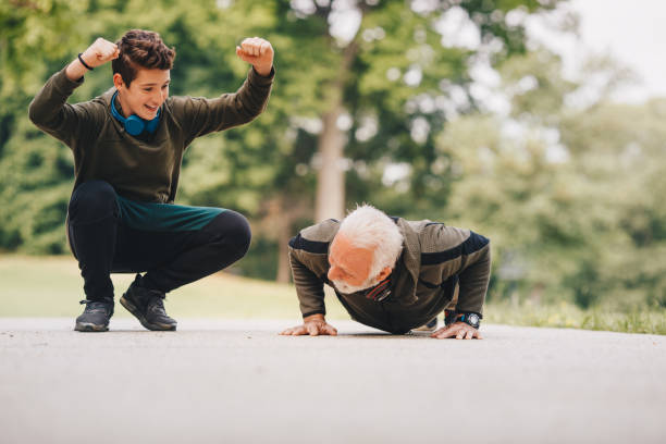 istock Grandfather telling his grandson how to do a good push-up 1225173680