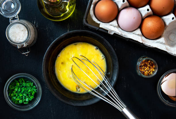istock Beat eggs in a bowl, and ingredients for making an omelette with green onions 1225176718