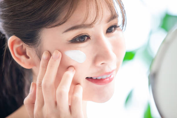 istock woman apply moisturizer on face 1225177841