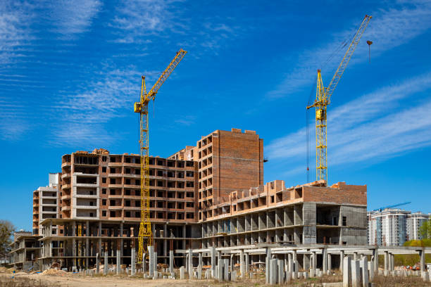 istock Work in progress on a new apartment block. Tall building under construction with cranes. Construction Site of New Building 1225178202