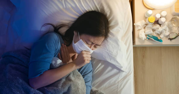 istock asian woman cough in bedroom 1225178428