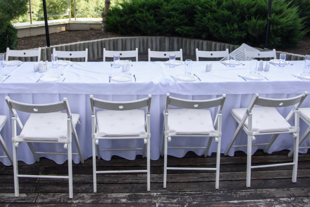 istock White served table outdoor on background of green trees 1225180074