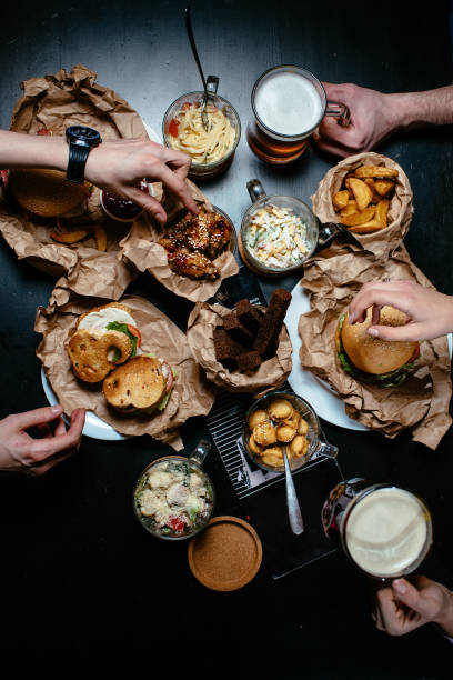 Friends all together at restaurant having meal top view Friends all together at restaurant having meal top view goodfood stock pictures, royalty-free photos & images