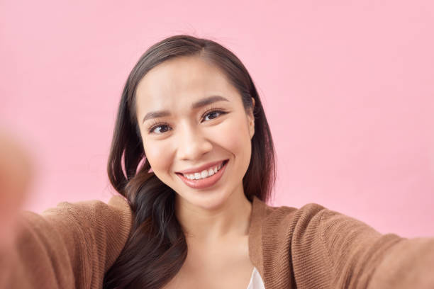 istock Happy cute woman making selfie over pink background 1225180866