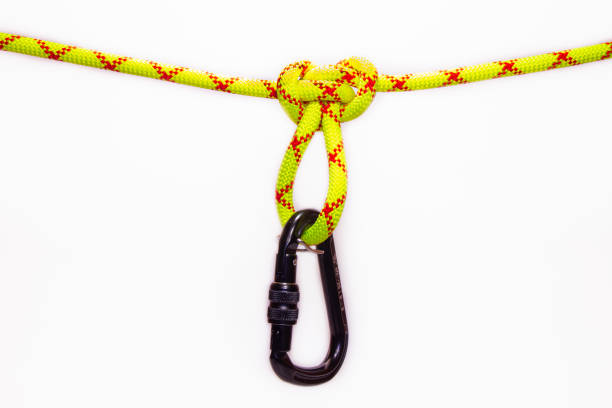 istock New Black oval touristic and alpinistic carabine hangs from Butterfly loop knot. Stretched colored, green rope for personal belaying. Self-insurance mustache. Isolated on white background 1225181152
