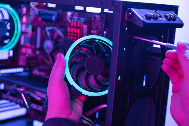 istock Man puts modern fan with blue led light in the computer using screwdriver 1225181986