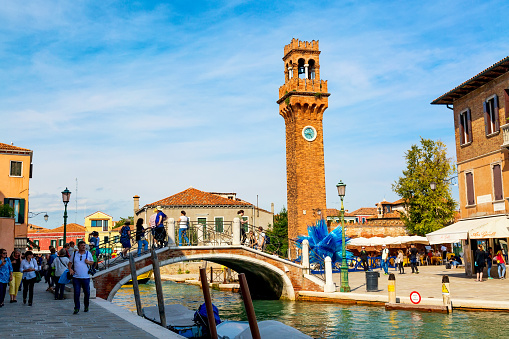 Murano, Italy - September, 2017: Murano, Venice, Italy in the summer season. Bridge with canal and Murano campanile.