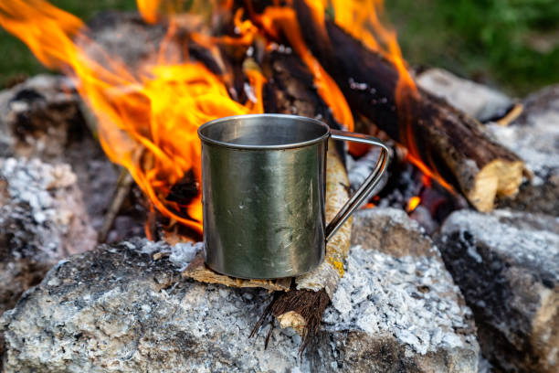 istock steel cup on an open fire in nature. Cooking on fire. Camping in summer. 1225183385