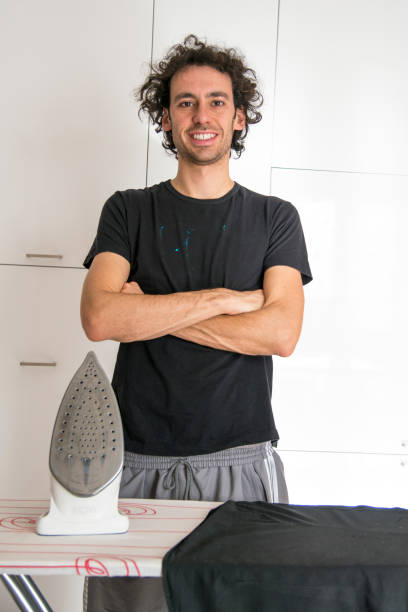 istock a young man ironing in the house 1225185675